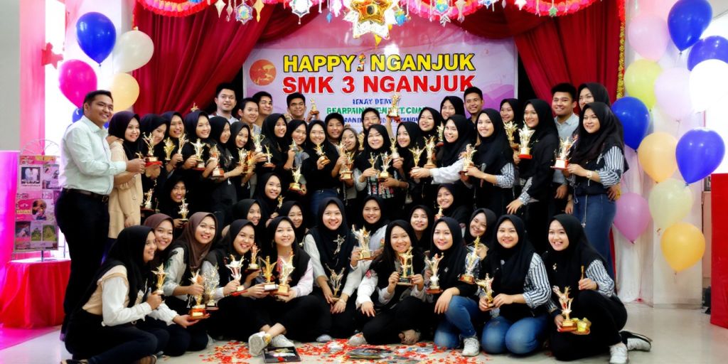 Siswa SMK 3 Nganjuk merayakan prestasi dengan trofi.